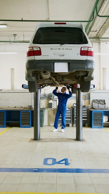 Automekaanikko työskentelee auton parissa korjaamossa
