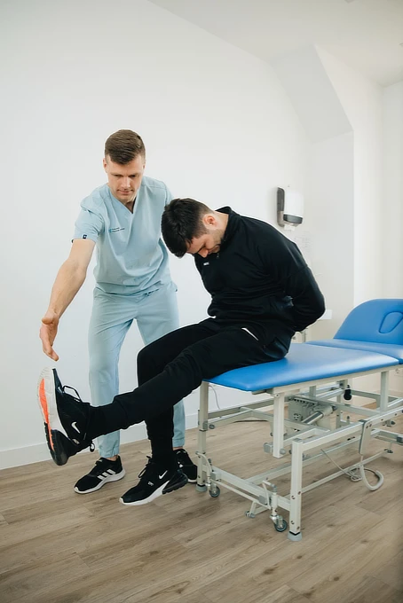 Fysioterapeutti ohjaa asiakkaan liikettä vastaanotolla