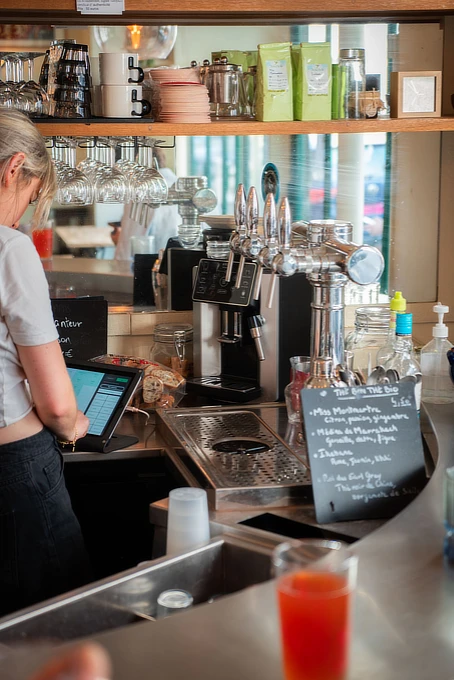 Barista kaataa maitovaahtoa kahvikuppiin
